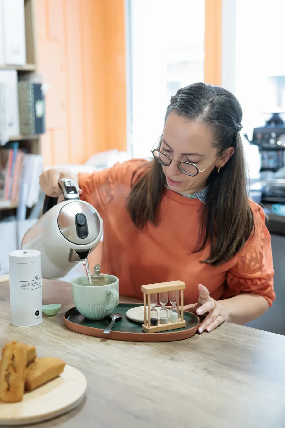 Larissa sert un thé au comptoir du salon