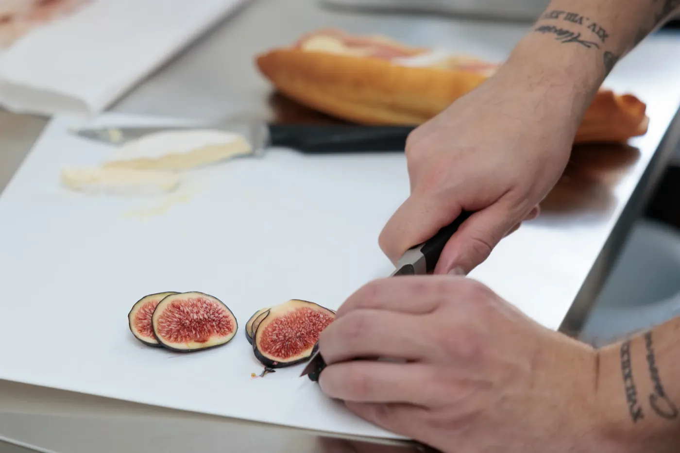 Figues fraîches tranchées, brie et baguette en préparation pour le snacking du midi